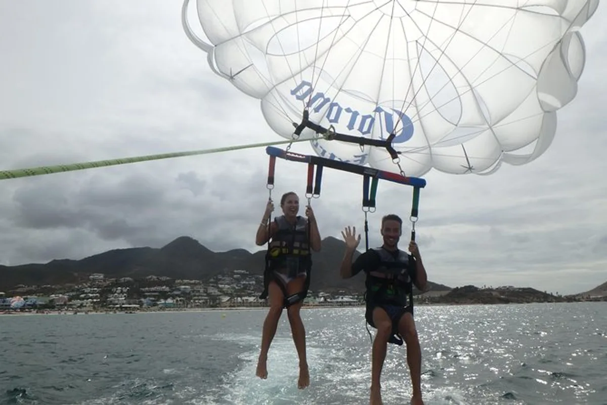 Aerial view of Orient Bay Beach, Pinel Island and turquoise reefs seen while parasailing in St Maarten